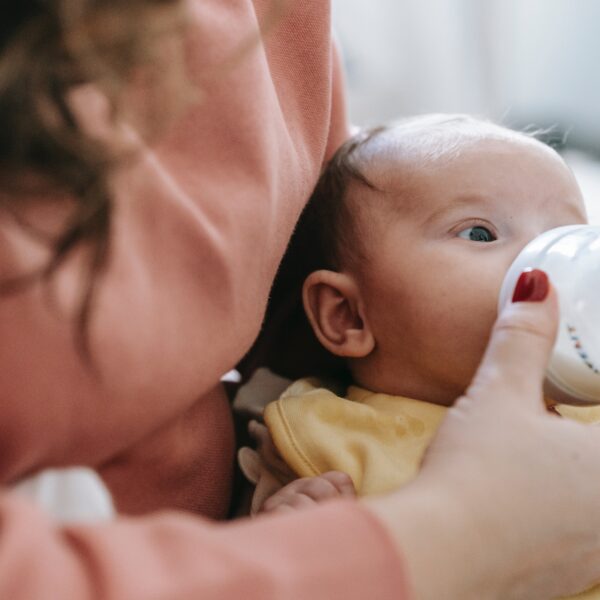 A parent bottle-feeding their baby